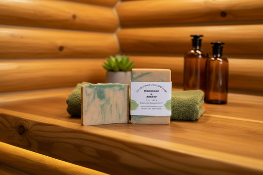 Two green and beige soap bars with a label on a wooden surface.